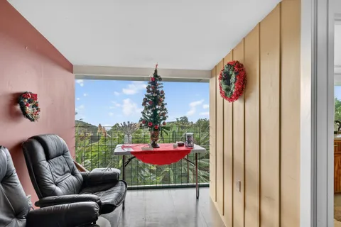 a view of a hallway with wooden floor windows and a livingroom