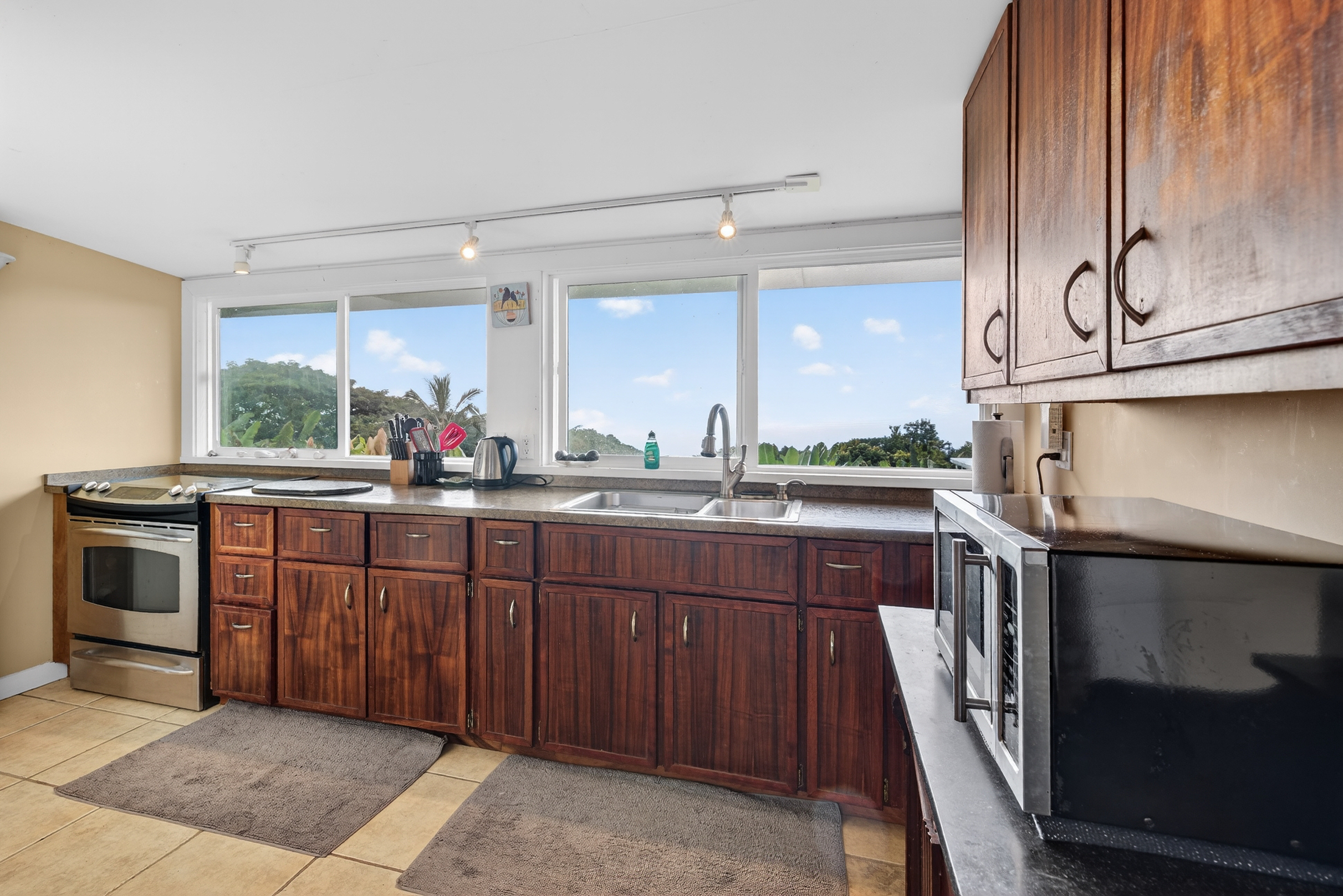 83-5531 Hawaii Belt Road Captain Cook, HI 96704 - Photo 23 of 30 a kitchen with stainless steel appliances granite countertop a sink and cabinets