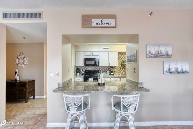 a kitchen with kitchen island granite countertop a table and chairs