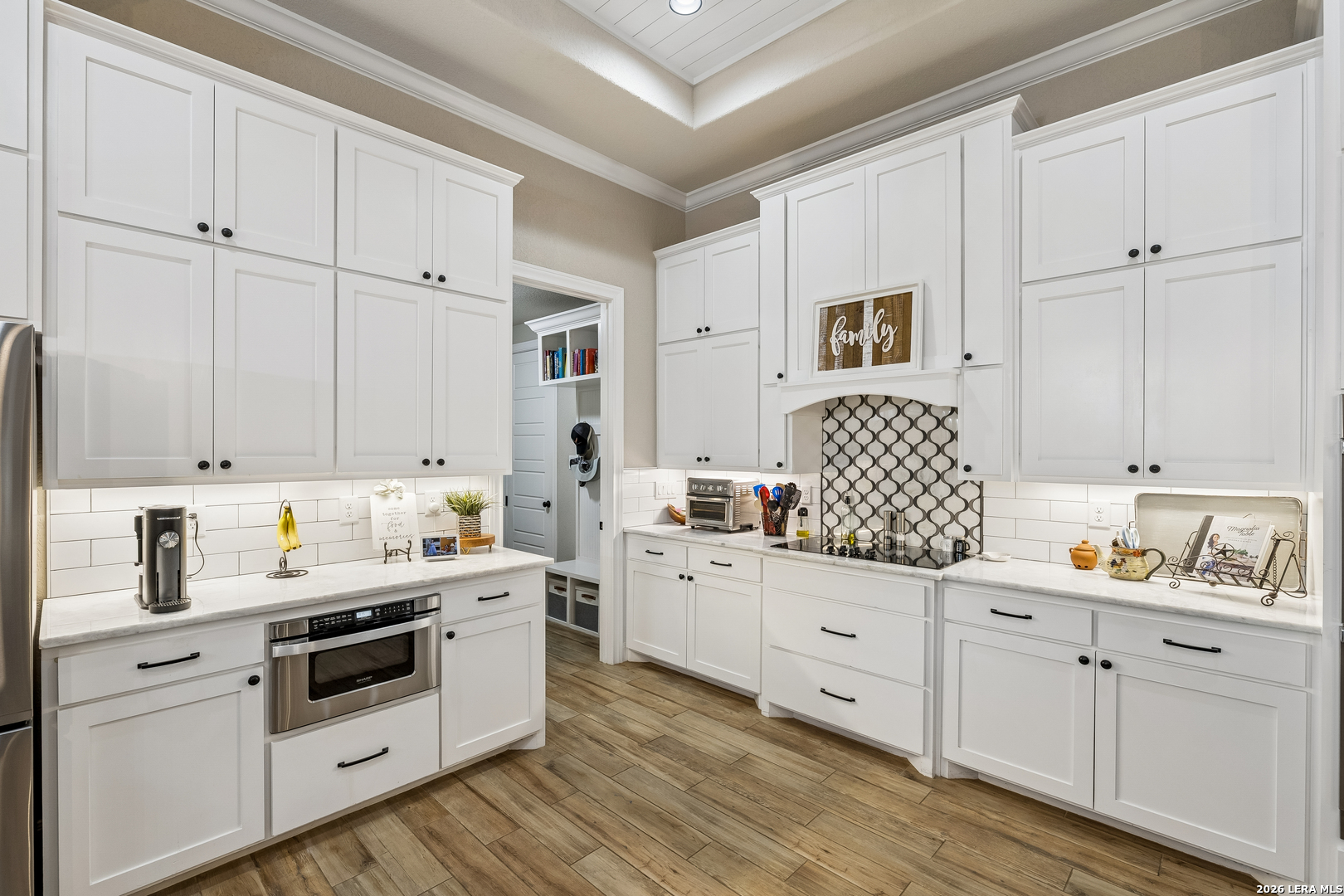 498 Double Gate Road Castroville, TX 78009 - Photo 11 of 28 a kitchen with white cabinets and white appliances