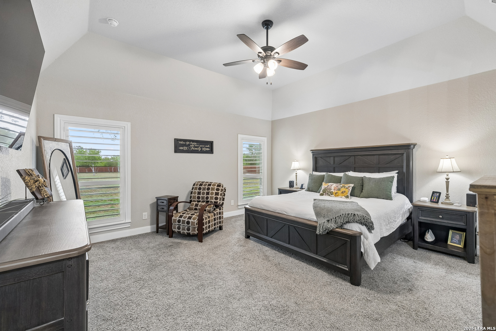 498 Double Gate Road Castroville, TX 78009 - Photo 13 of 28 a spacious bedroom with a bed and a chandelier