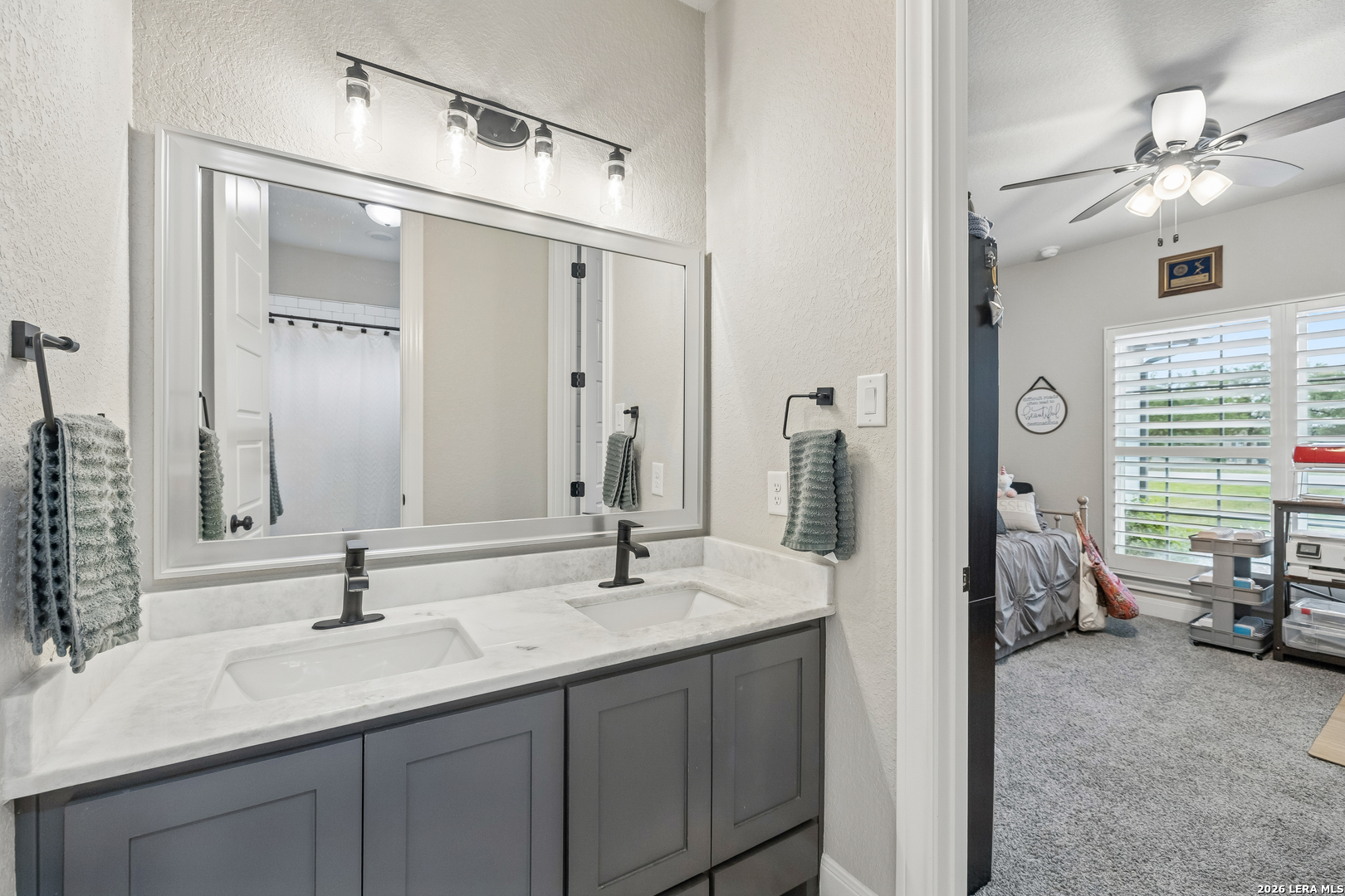 498 Double Gate Road Castroville, TX 78009 - Photo 20 of 28 a en suite bathroom with double sink and a mirror