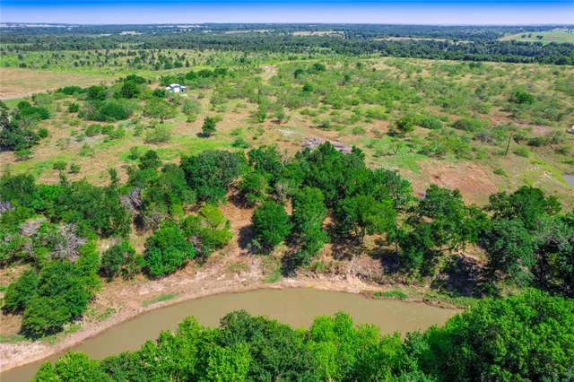 an aerial view of residential houses with outdoor space and trees