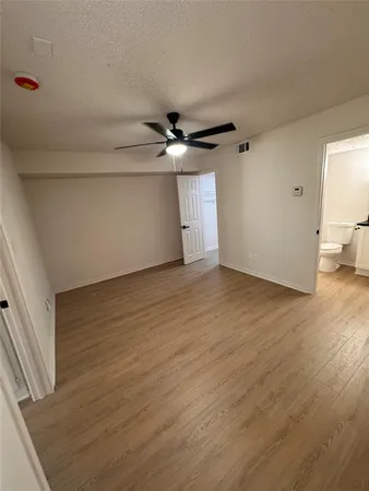 a view of a livingroom with wooden floor and a ceiling fan