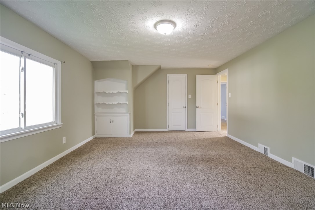 736 Quilliams Road Cleveland Heights, OH 44121 - Photo 12 of 20 Unfurnished bedroom with light colored carpet and a textured ceiling
