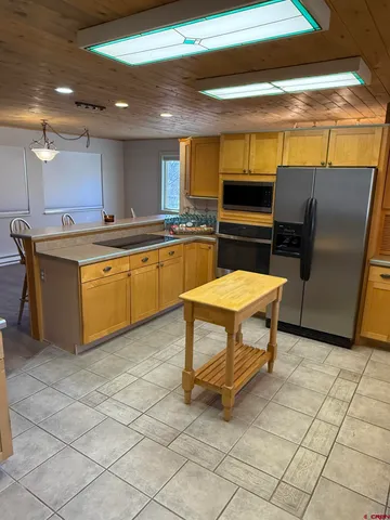 a kitchen with stainless steel appliances a stove a sink and a refrigerator