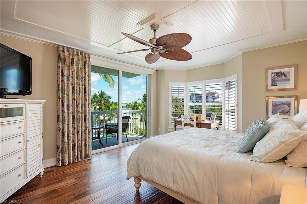 9155 Gulf Shore Drive, Unit 401 Naples, FL 34108 - Photo 11 of 12 a bedroom with a bed and a flat screen tv