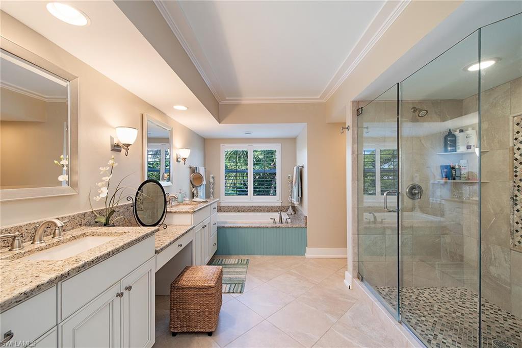 9155 Gulf Shore Drive, Unit 401 Naples, FL 34108 - Photo 12 of 12 a bathroom with a granite countertop sink mirror and shower