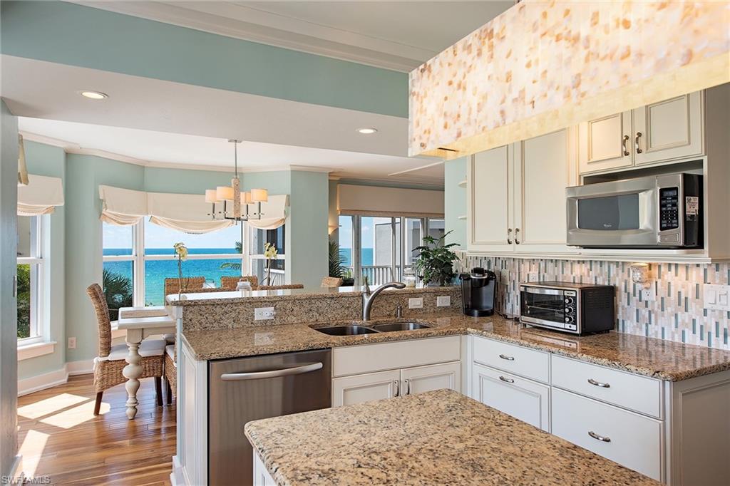 9155 Gulf Shore Drive, Unit 401 Naples, FL 34108 - Photo 6 of 12 a kitchen with stainless steel appliances granite countertop a stove and a sink