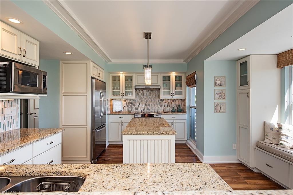 9155 Gulf Shore Drive, Unit 401 Naples, FL 34108 - Photo 7 of 12 a kitchen with stainless steel appliances kitchen island granite countertop a refrigerator stove top oven and sink