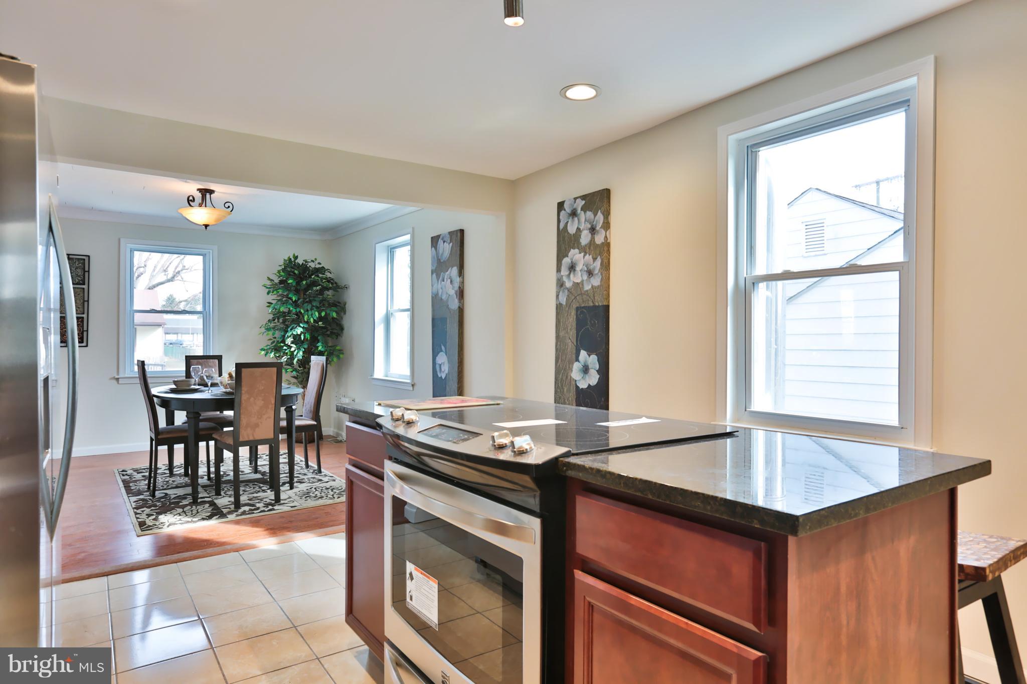 4115 Klausmier Road Baltimore, MD 21236 - Photo 12 of 30 a kitchen with granite countertop a stove dining table and chairs