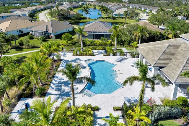 a view of a swimming pool with a patio and a yard