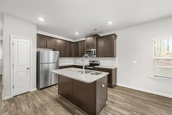 a kitchen with kitchen island a sink stainless steel appliances and cabinets