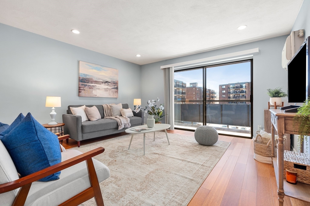 a living room with furniture a flat screen tv and a floor to ceiling window
