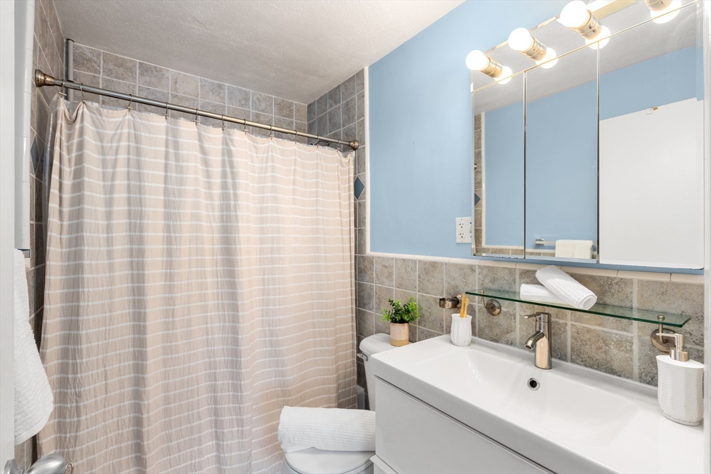 32 Whites Avenue, Unit E441 Watertown, MA 02472 - Photo 16 of 34 a bathroom with a sink and a mirror