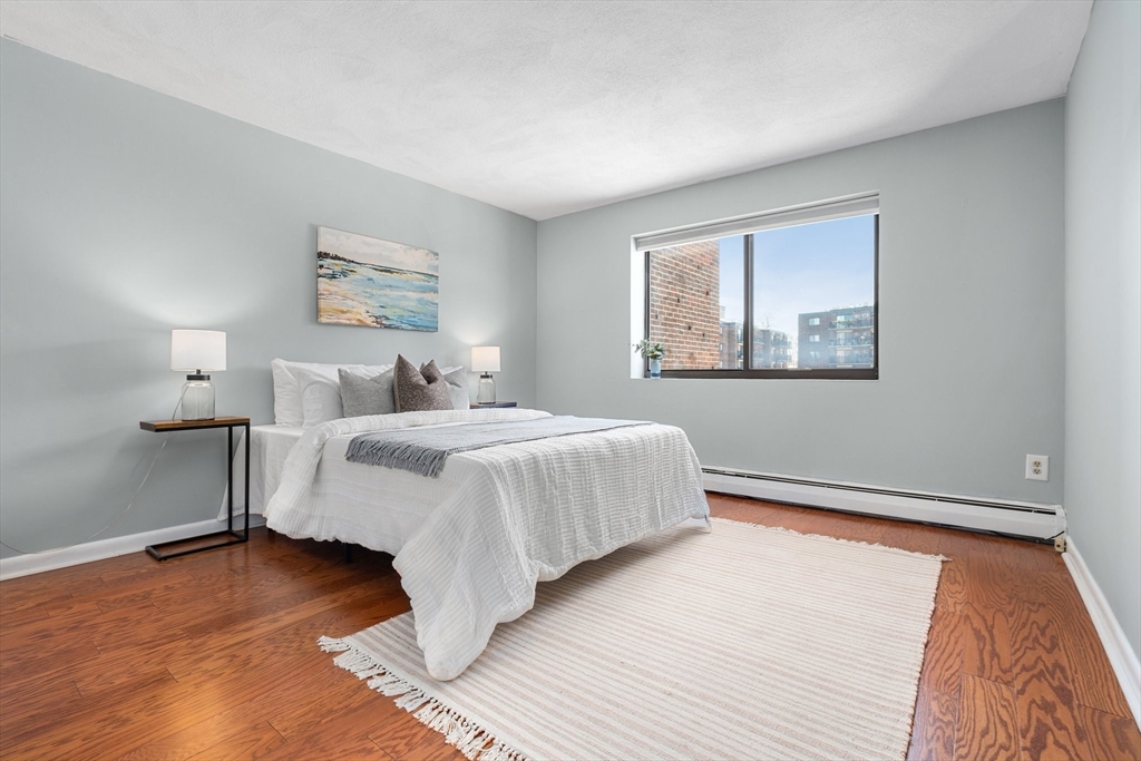 32 Whites Avenue, Unit E441 Watertown, MA 02472 - Photo 18 of 34 a bedroom with a bed and a painting on the wall