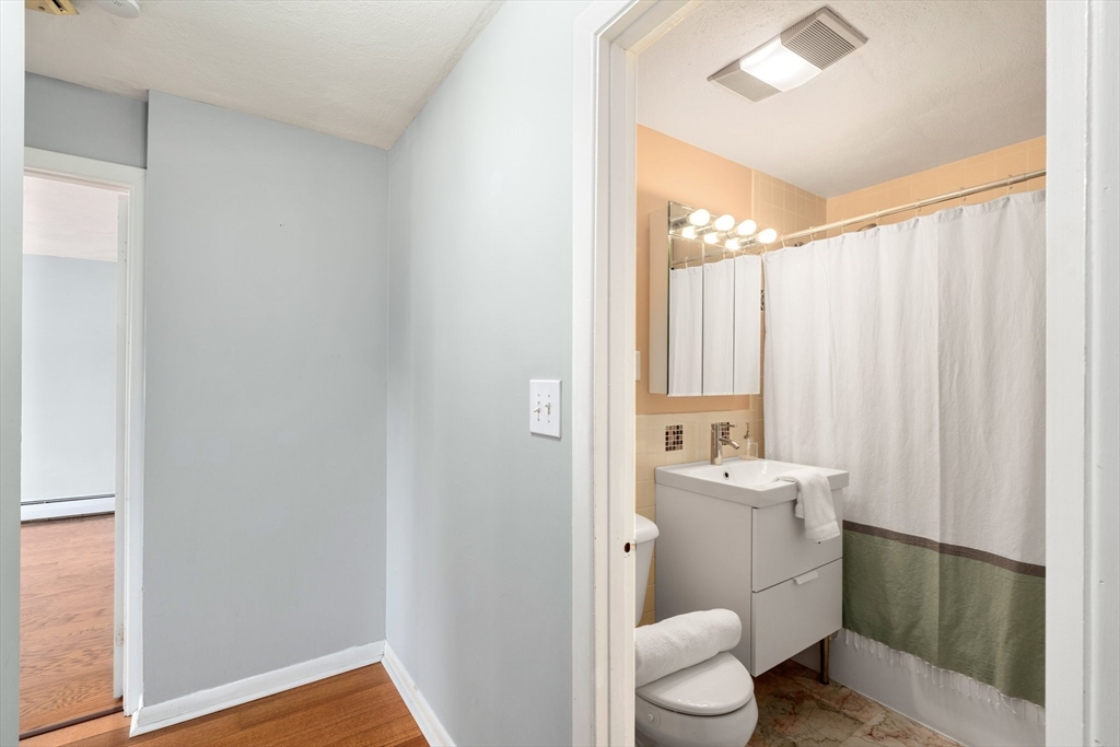 32 Whites Avenue, Unit E441 Watertown, MA 02472 - Photo 19 of 34 a bathroom with a sink a toilet and shower
