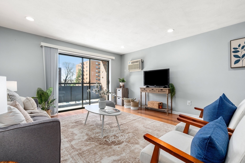 32 Whites Avenue, Unit E441 Watertown, MA 02472 - Photo 2 of 34 a living room with furniture and a flat screen tv