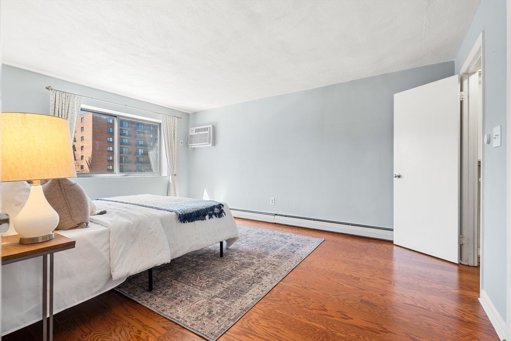 32 Whites Avenue, Unit E441 Watertown, MA 02472 - Photo 21 of 34 a bedroom with a bed and wooden floor