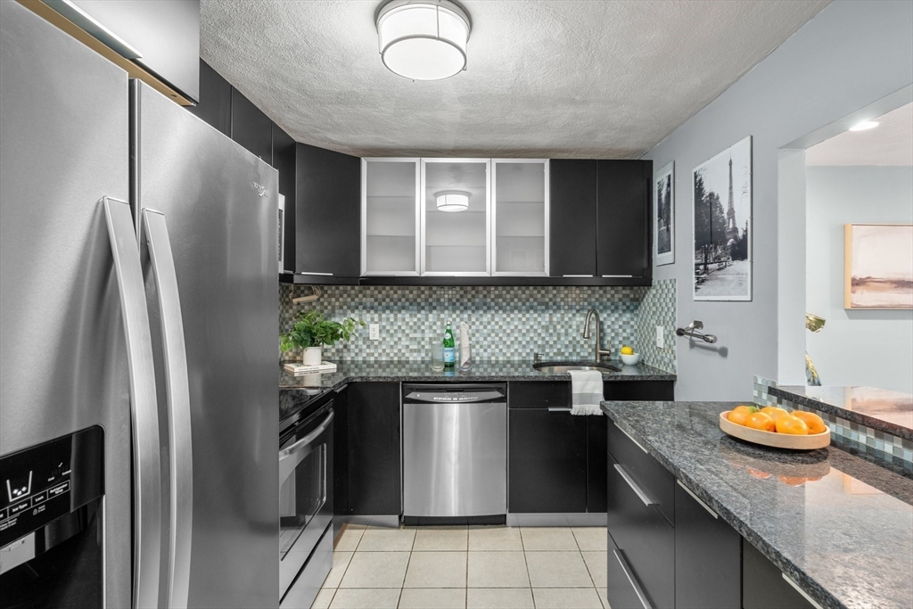 32 Whites Avenue, Unit E441 Watertown, MA 02472 - Photo 7 of 34 a kitchen with stainless steel appliances granite countertop a sink a stove and a refrigerator