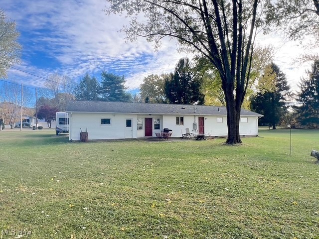 6852 Riverside Road Southeast Uhrichsville, OH 44683 - Photo 20 of 30 Back of property with a lawn and a patio