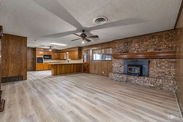 a large kitchen with wooden floors a center island stainless steel appliances and cabinets