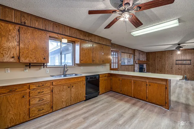 a kitchen with stainless steel appliances granite countertop a refrigerator a sink dishwasher and a stove with wooden floor