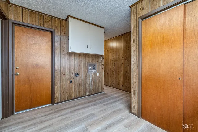 an empty room with windows and ceiling fan