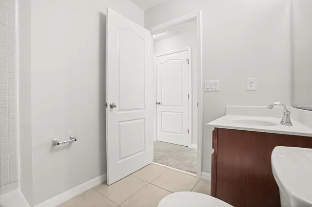 a bathroom with a sink a toilet a mirror and shower