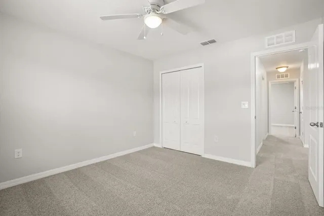 an empty room with a ceiling fan and a bathroom