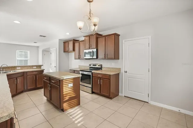 a kitchen with stainless steel appliances granite countertop a stove a sink and a refrigerator
