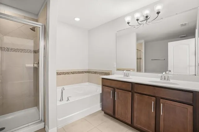 a bathroom with a tub a sink and mirror