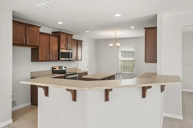 a kitchen with stainless steel appliances granite countertop a sink a stove and cabinets