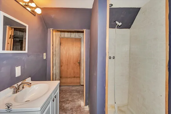 a bathroom with a granite countertop sink a mirror and a shower