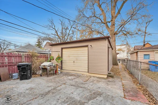 a view of a patio with table and chairs and a barbeque