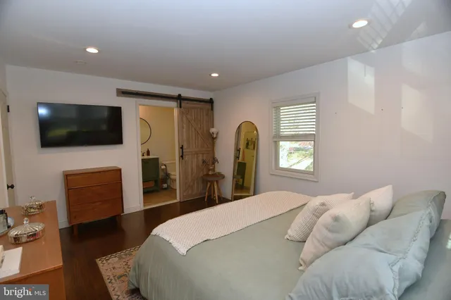 a bedroom with a bed tv and a large window