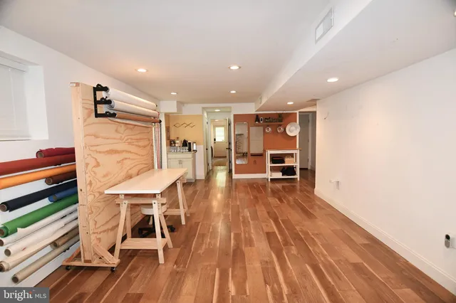 a view of a living room a dining room wooden floor and a window