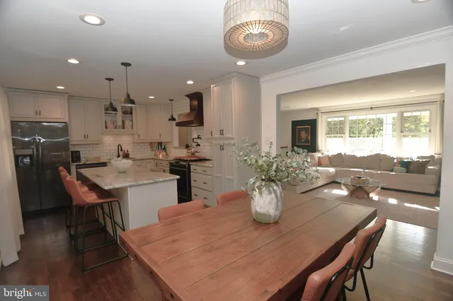 a dining room with stainless steel appliances kitchen island granite countertop a dining table chairs and view living room