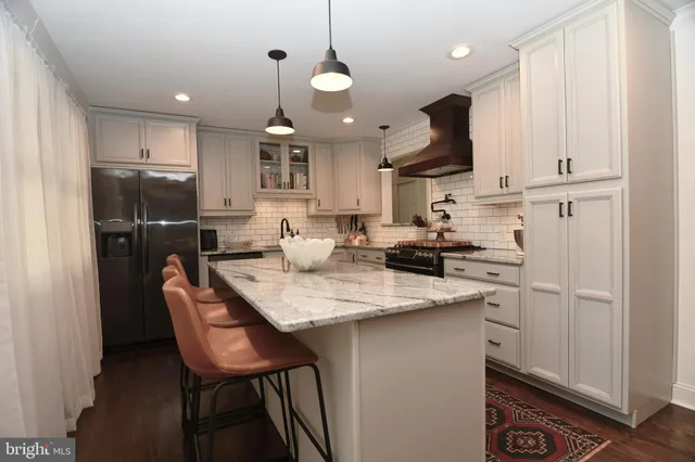 a kitchen with stainless steel appliances granite countertop a sink a stove a refrigerator and island