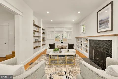 a living room with furniture kitchen view and large window