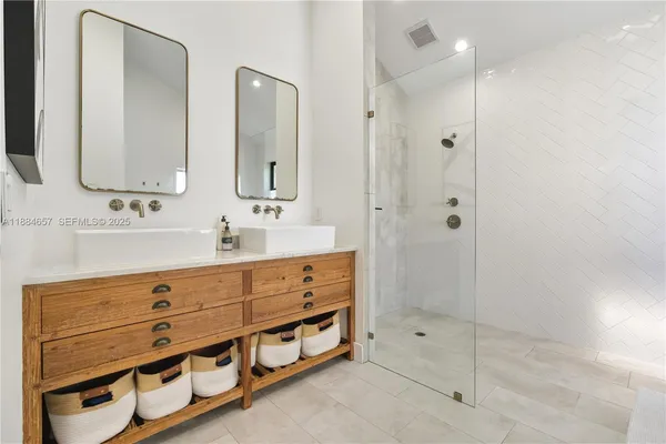a bathroom with double sink and three mirror