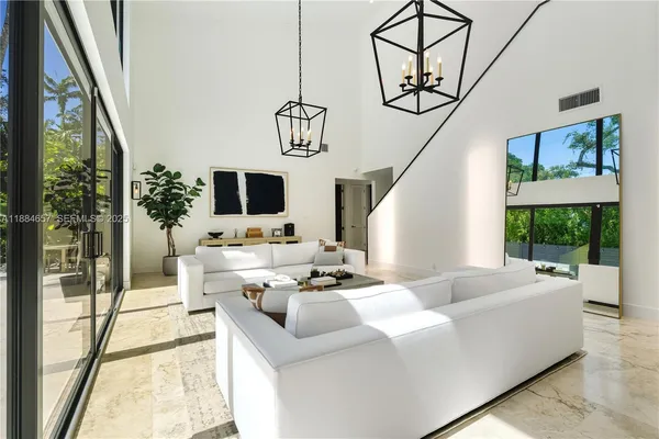 a living room with furniture a flat screen tv and a floor to ceiling window