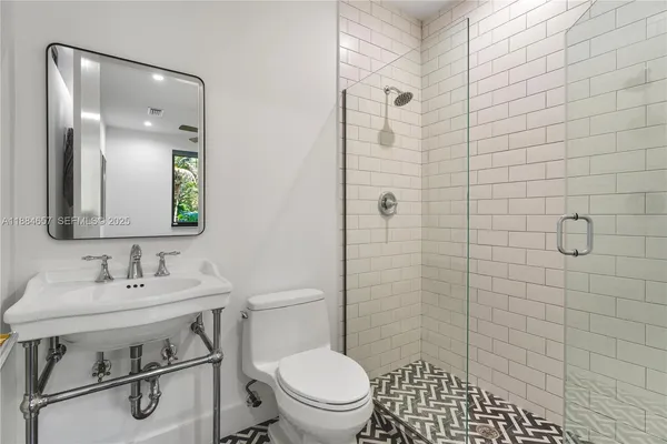 a bathroom with a sink a toilet and shower