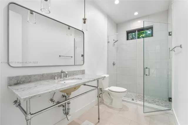 a bathroom with a sink vanity mirror and toilet