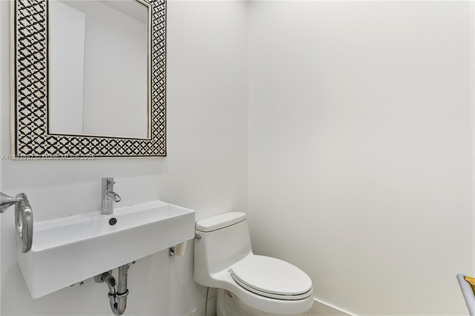 3782 El Prado Boulevard, Unit 1 Miami, FL 33133 - Photo 25 of 30 a bathroom with a toilet sink and mirror