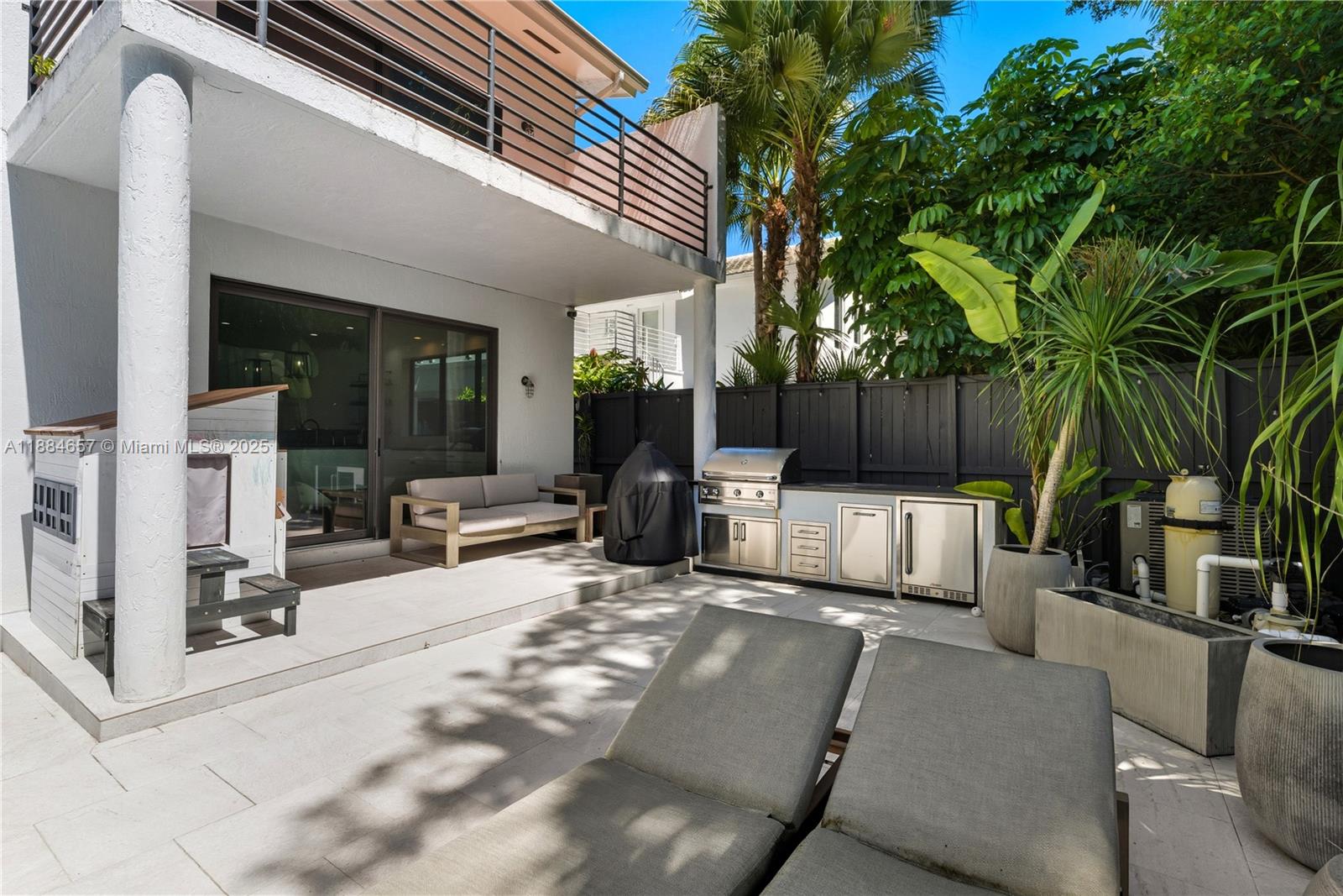 3782 El Prado Boulevard, Unit 1 Miami, FL 33133 - Photo 29 of 30 a view of a patio with table and chairs potted plants and large tree