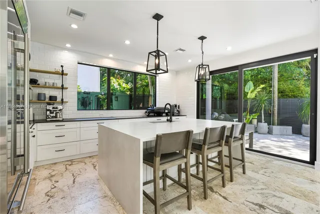 a kitchen with kitchen island a counter top space appliances and a dining table