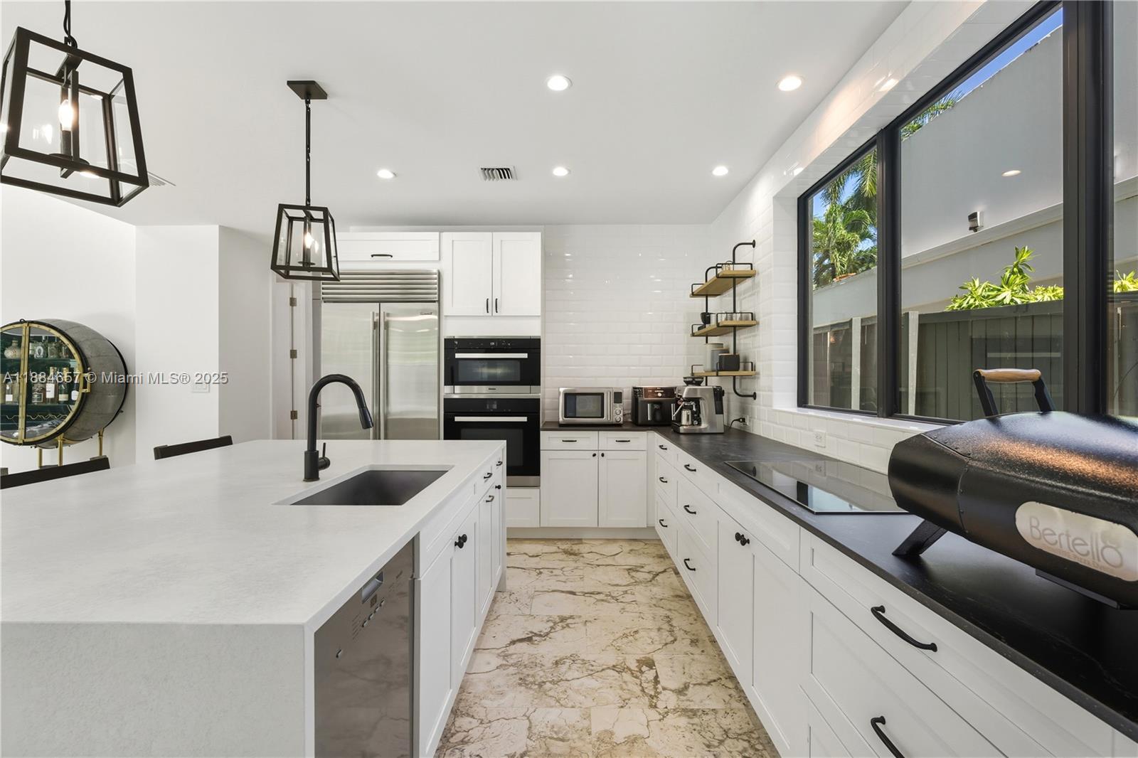 3782 El Prado Boulevard, Unit 1 Miami, FL 33133 - Photo 8 of 30 a large white kitchen with a large window