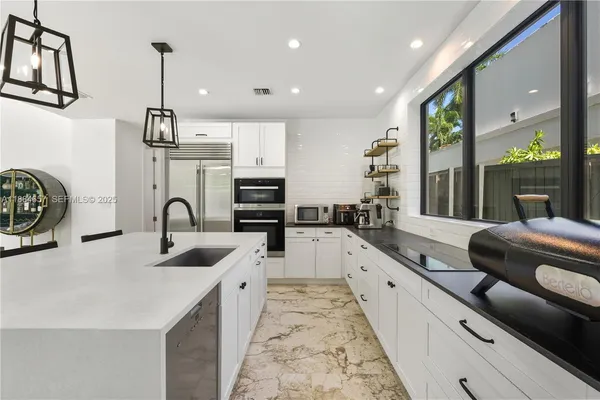 a large white kitchen with a large window