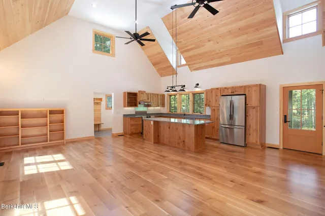 a room with lots of wooden furniture and a kitchen view
